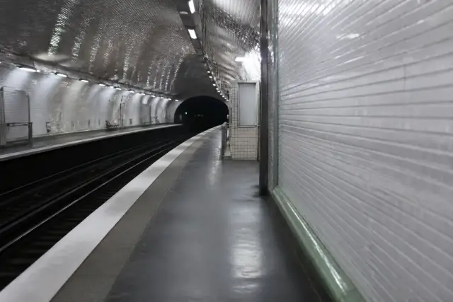 Quai de métro vide de nuit avec un écran lumineux