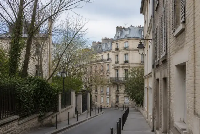 Rue de quartier avec immeubles de pierre et arbres dans le nord-ouest de Paris