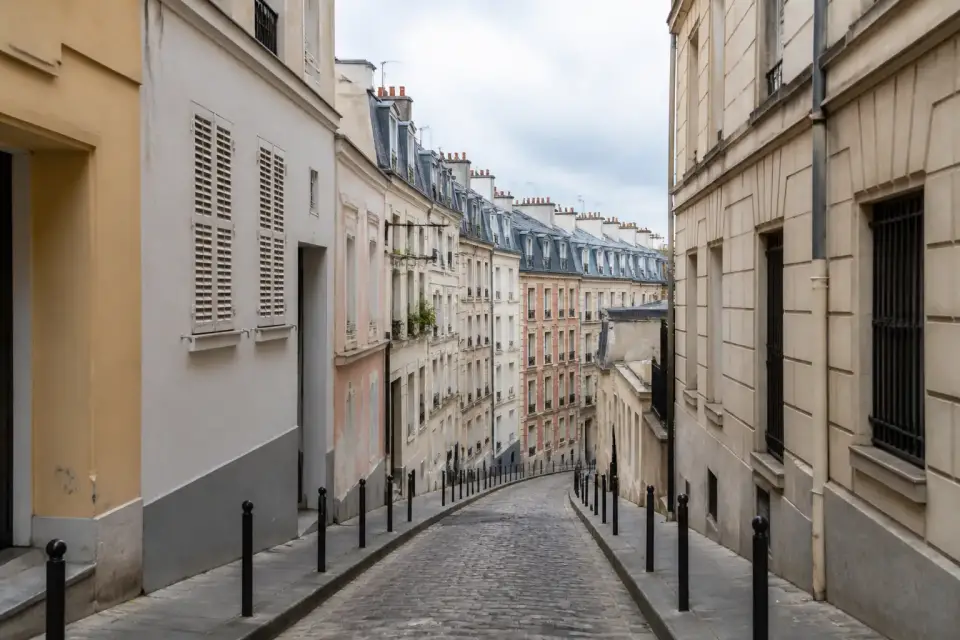 Rue en pente bordée de petits immeubles et de façades colorées dans le sud de Paris