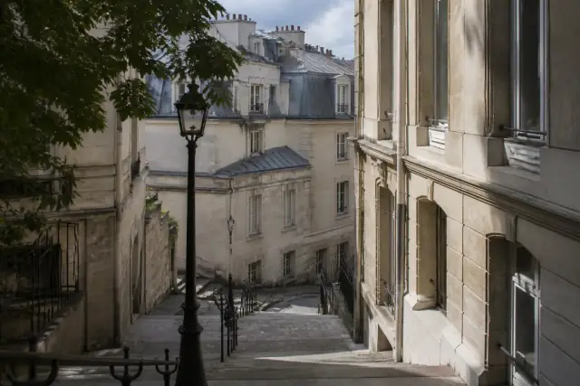 Place ombragée et façades de pierre dans un quartier étudiant de Paris